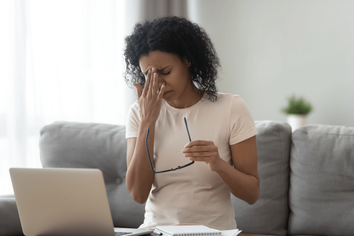 exhausted woman taking off glasses and suffering from dry eyes