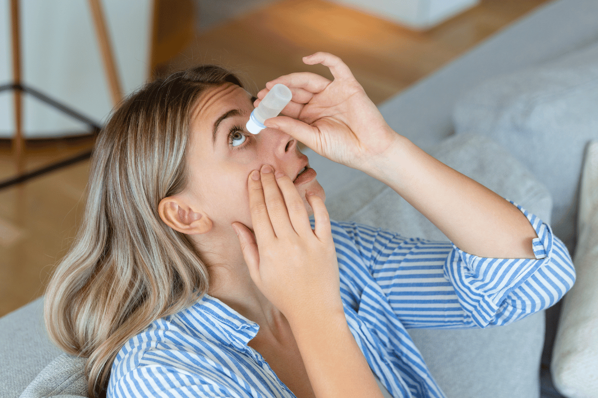 woman putting eye drops in her eye