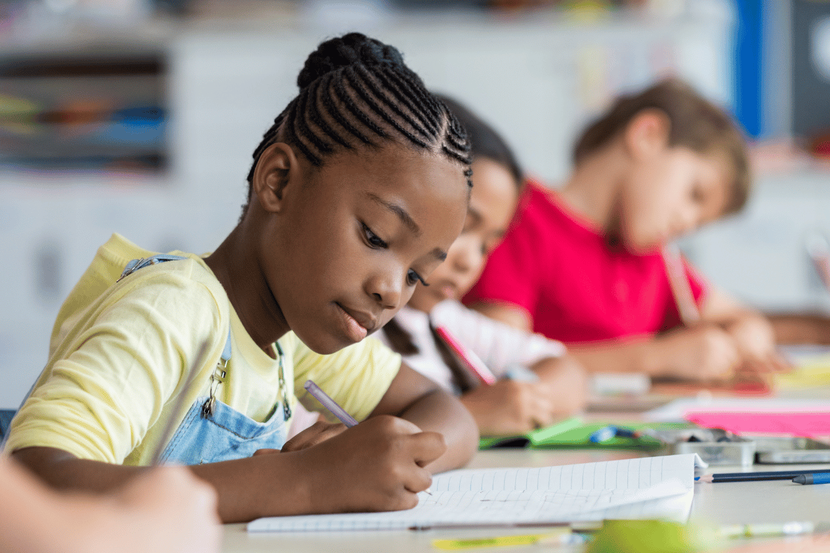 children sitting in a classroom doing schoolwork